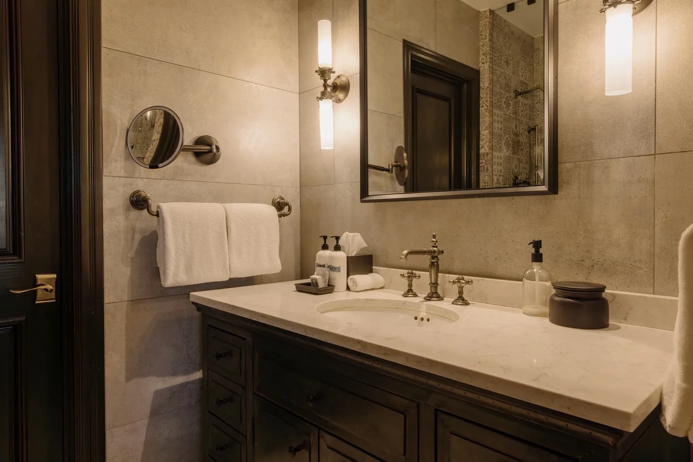 Un lavabo de baño con un espejo amplio y toallas colgadas cerca.