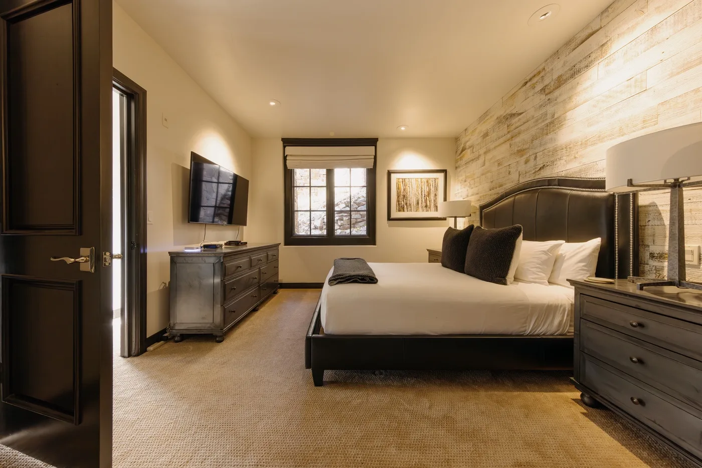 Un dormitorio con una cama grande, muebles oscuros y una ventana.