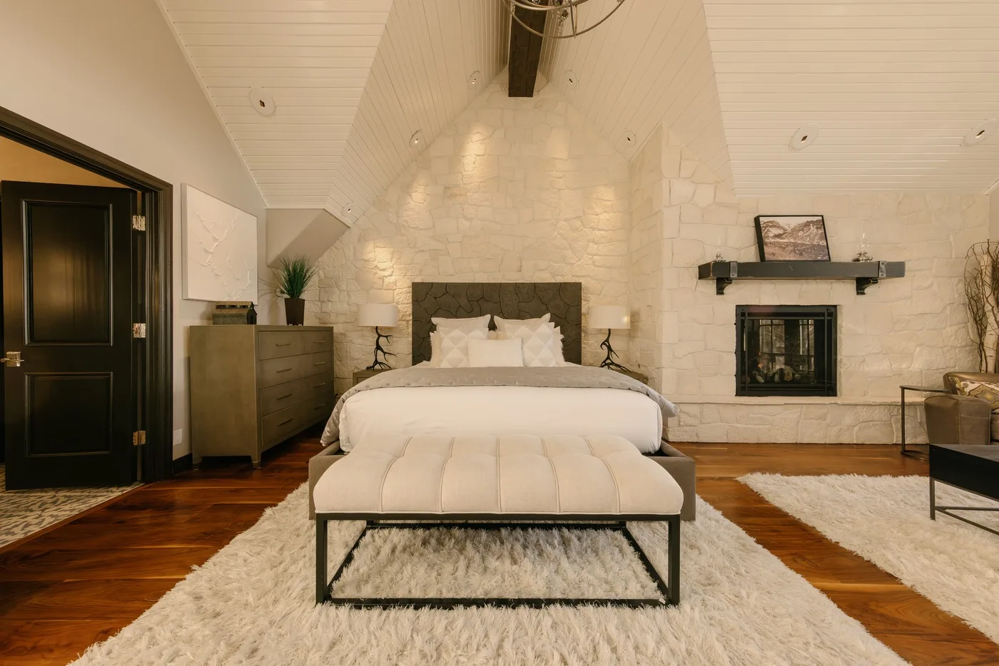 Un dormitorio con una cama bajo un techo alto e inclinado.