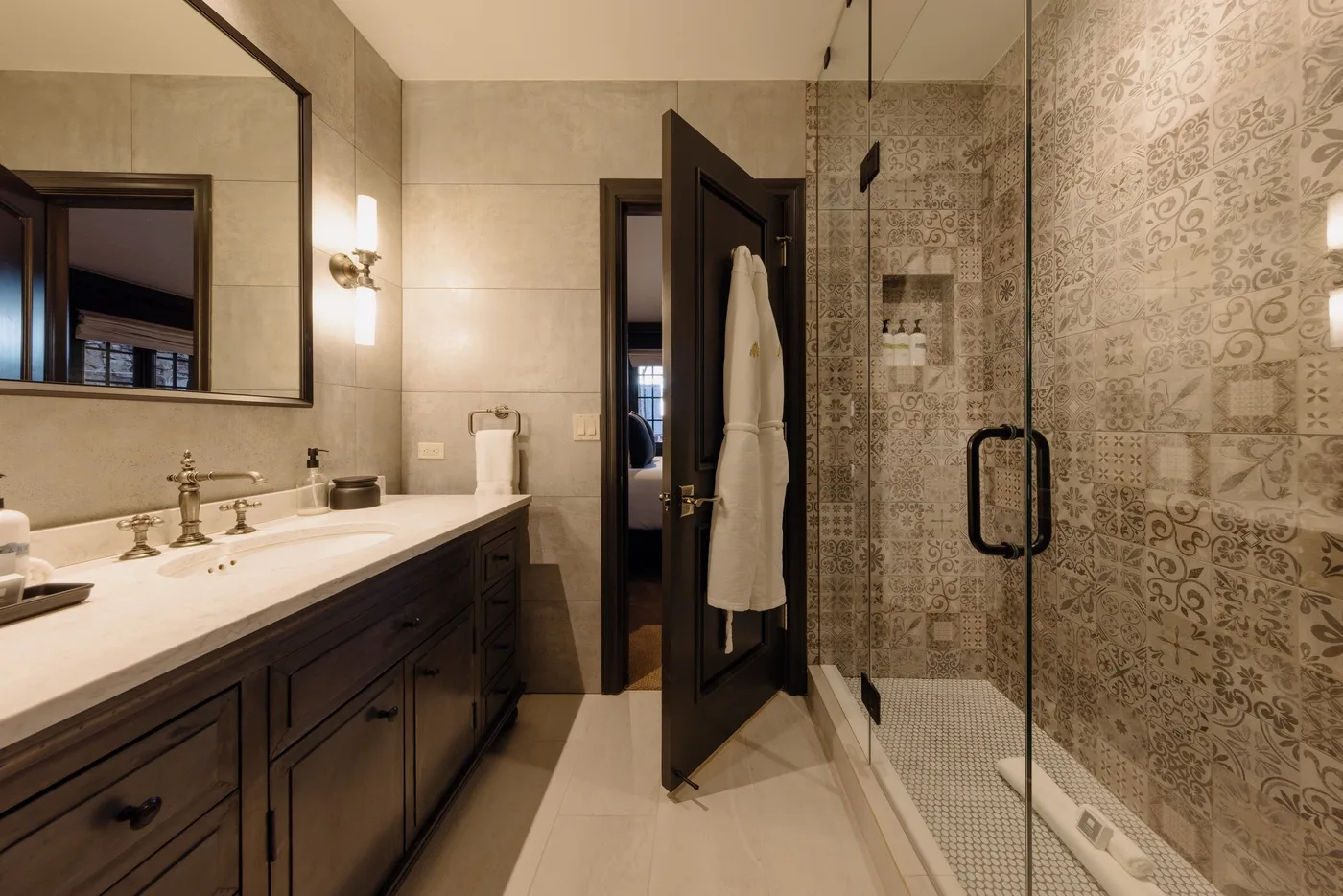 Un baño con un lavabo largo y una ducha con mampara de vidrio.