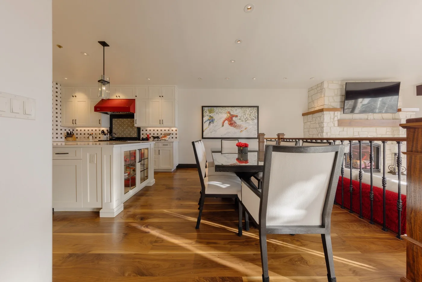 Un comedor abierto junto a la cocina, con una mesa junto a una chimenea.