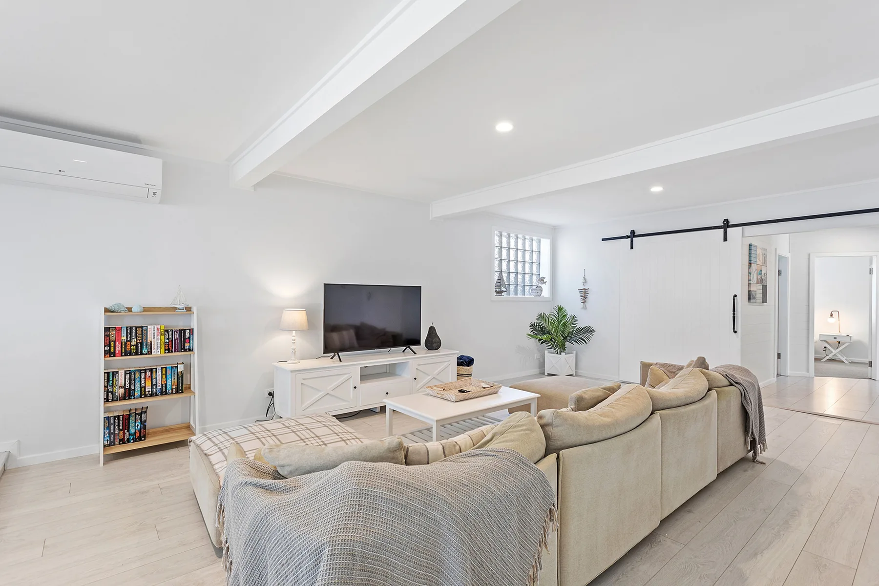 A bright living room with seating, a television, and a low coffee table.