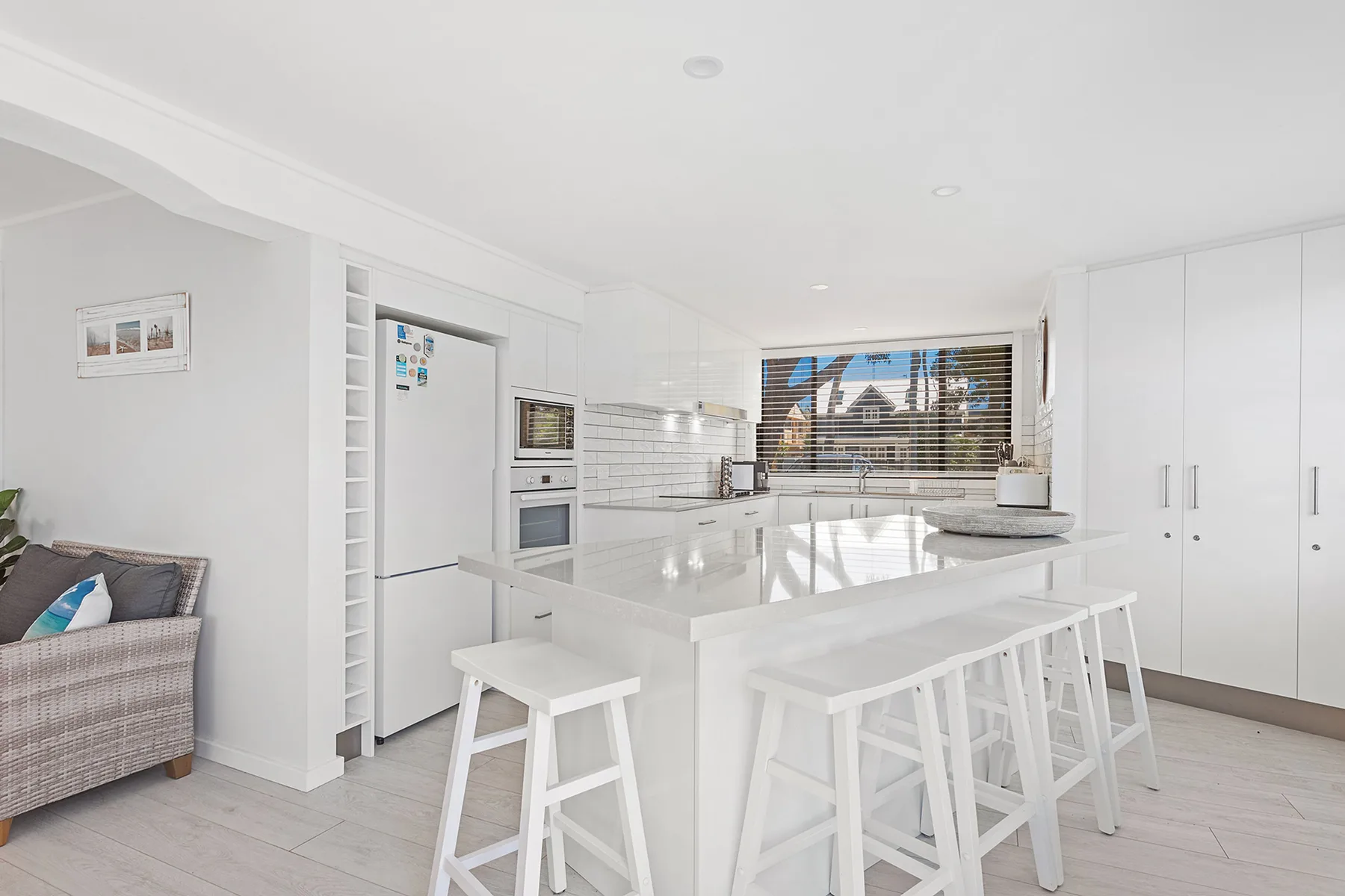 A bright kitchen with a central island and bar seating.