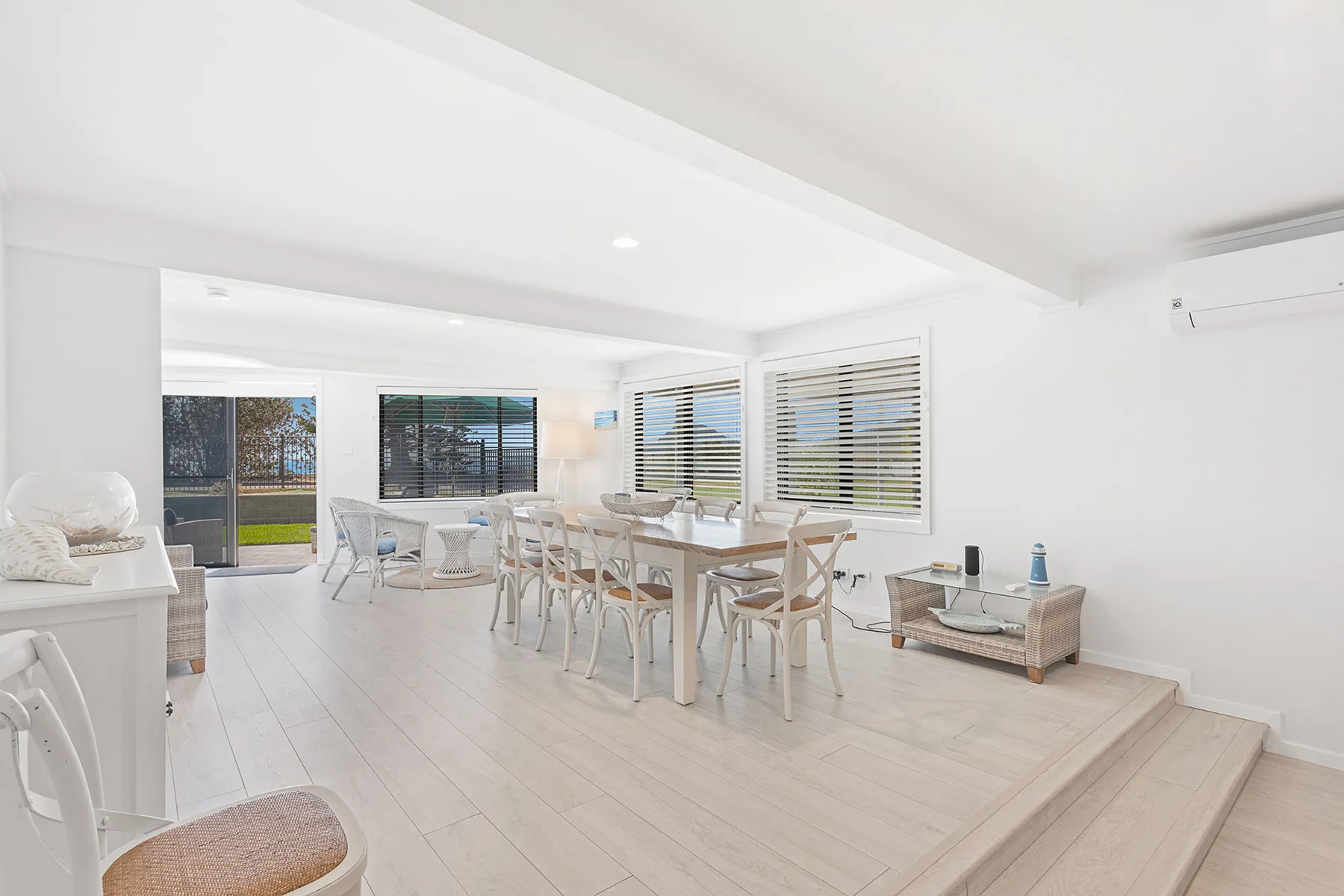 A bright dining area with a long table and large windows.