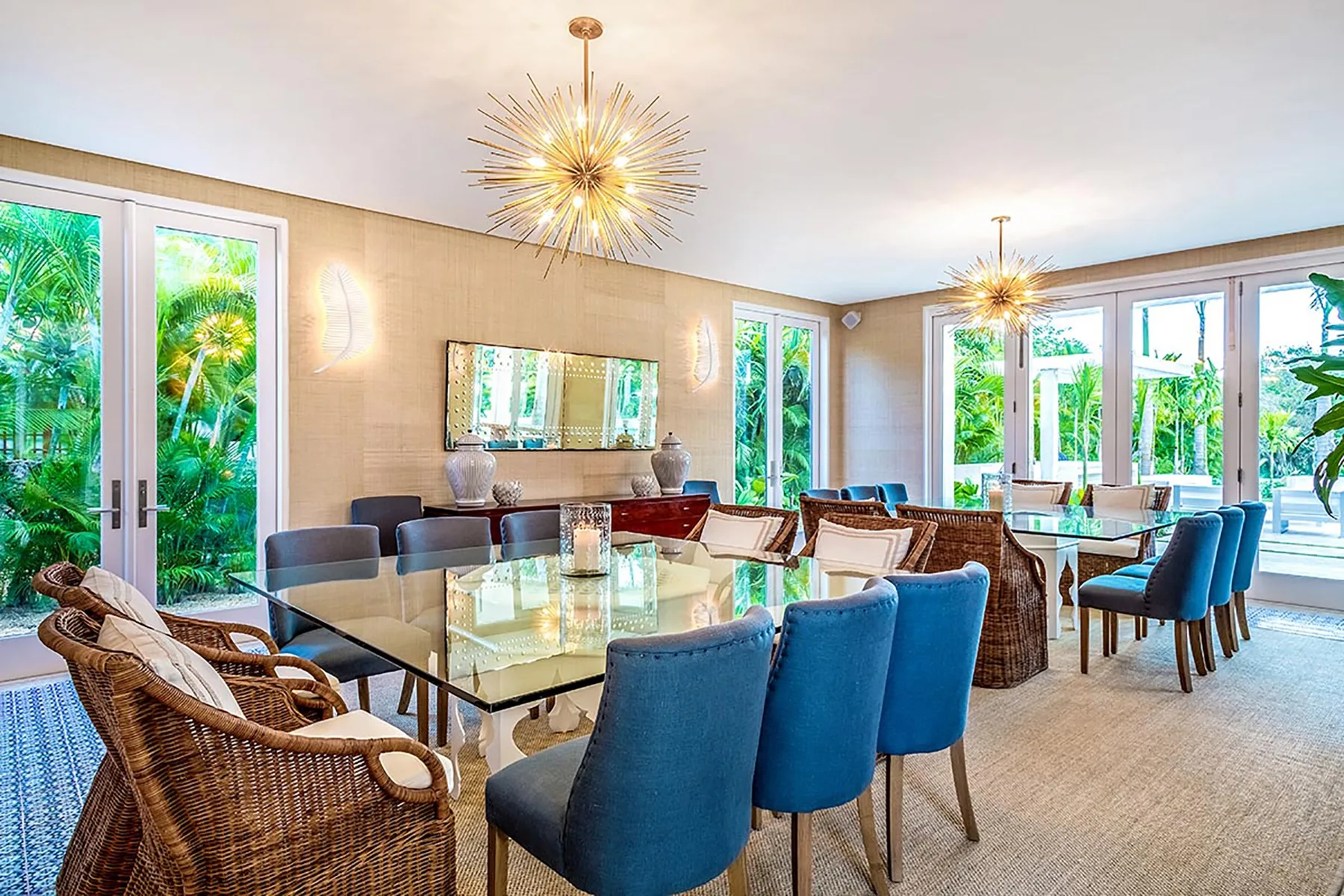 A bright dining area with a glass table and blue upholstered seating.