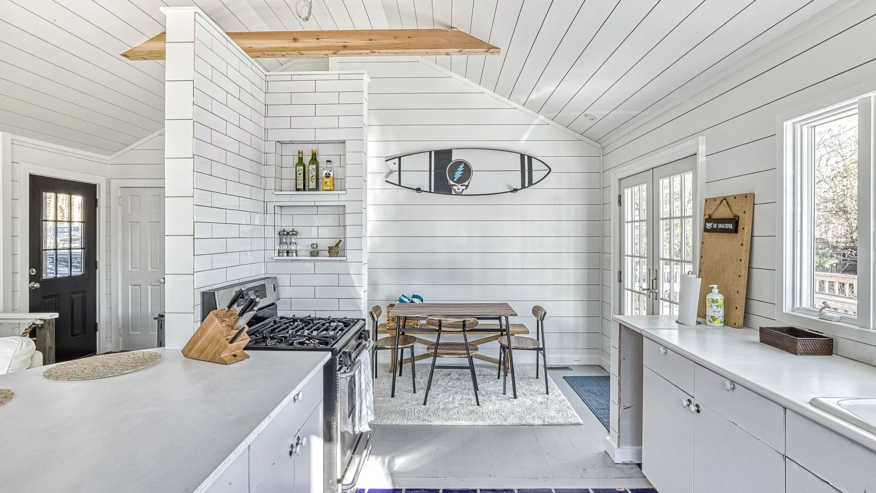 Una cocina luminosa con una mesa de comedor y gabinetes blancos.
