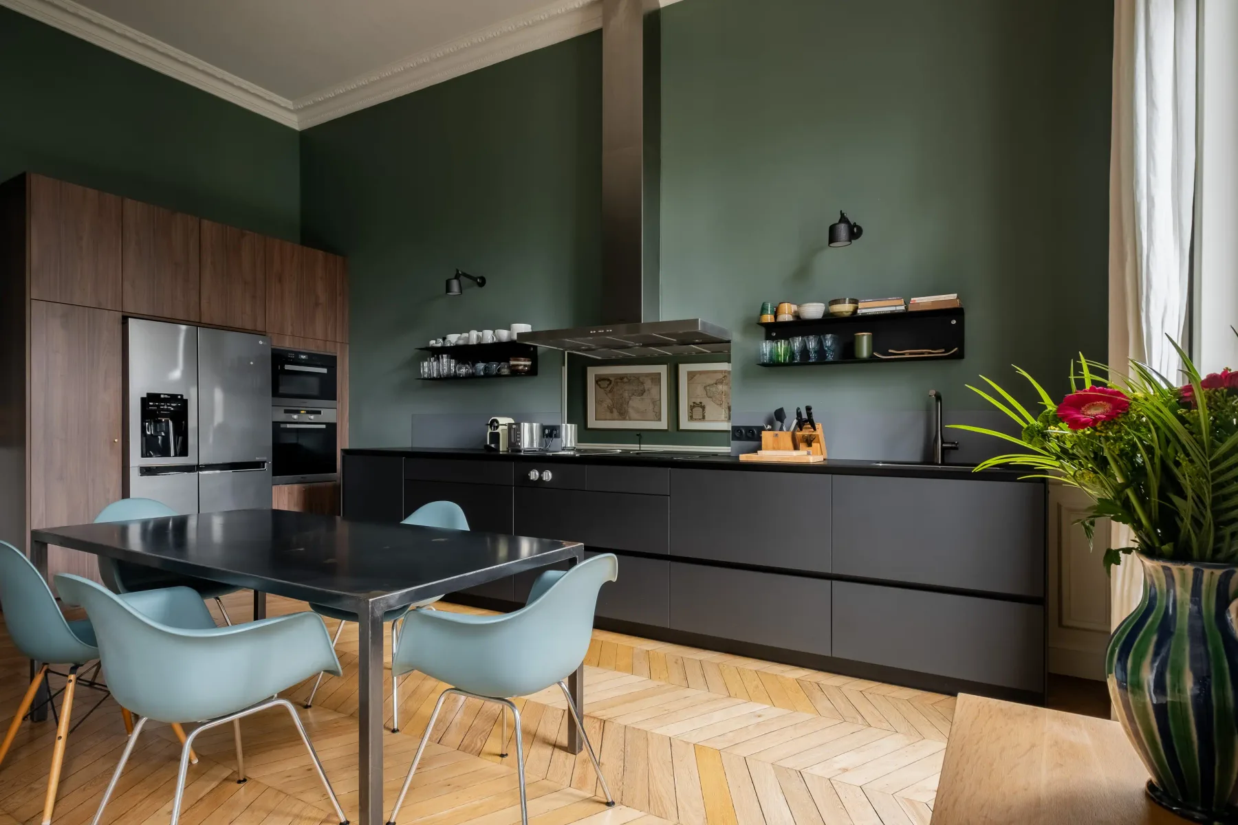 Una cocina moderna con armarios oscuros, una isla central y asientos azules.