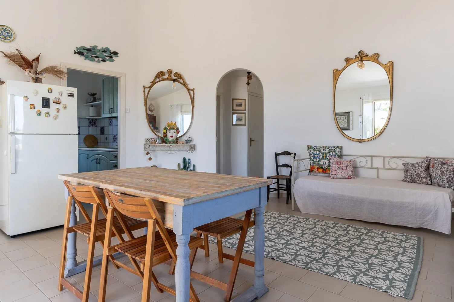 Un comedor con zona de estar, mesa de madera y diván.