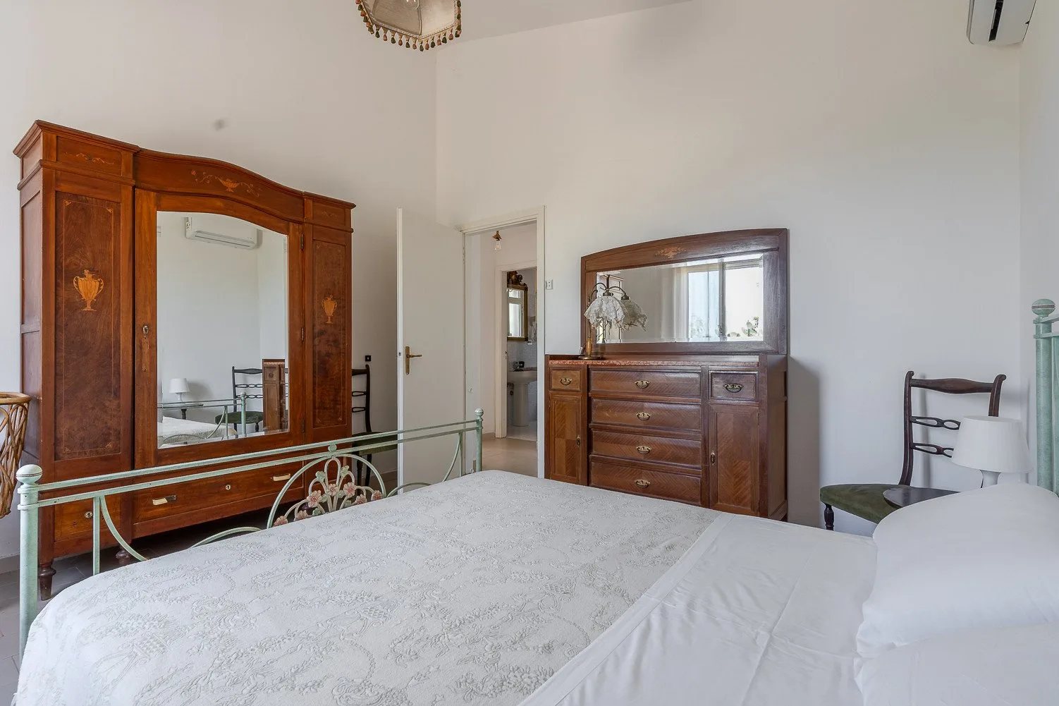 Un dormitorio con una cama, un armario grande de madera y una cómoda a juego.