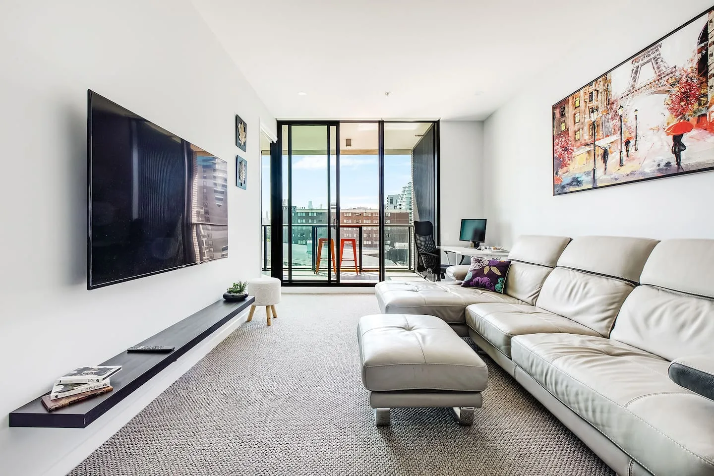 Get comfortable in the living room. There’s plush sofa seating and a large wall-mounted TV for movie nights at home.
