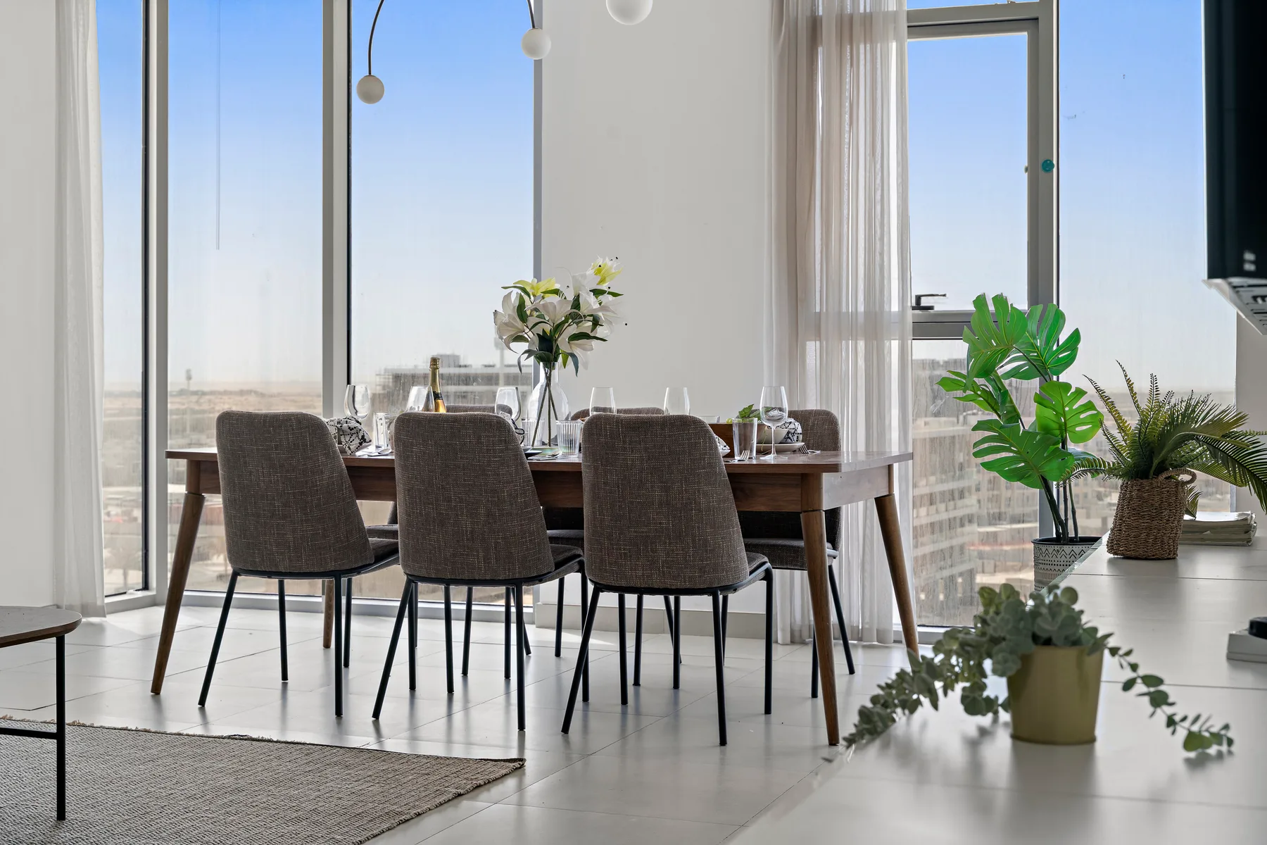 Un comedor luminoso cuenta con una mesa y sillas junto a ventanales.