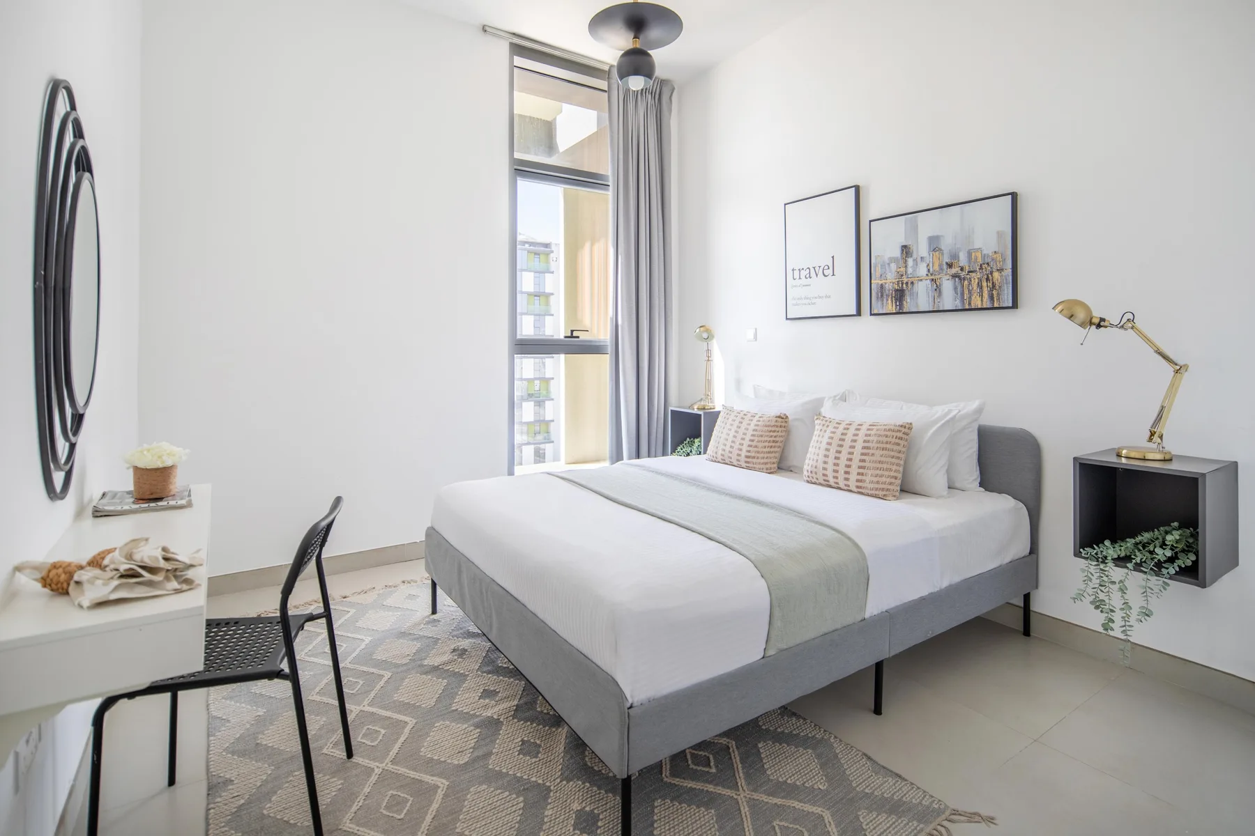 Un dormitorio luminoso con una cama bien arreglada y ventanas altas.
