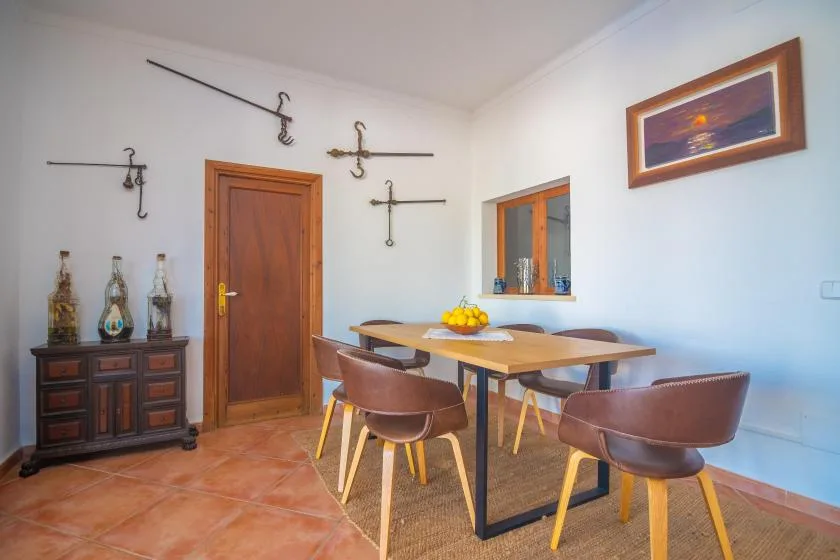 A dining area with a wooden table and chairs beside a brown door.