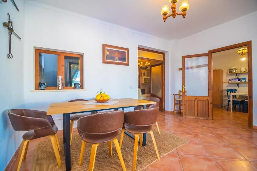 A dining area with a wooden table and chairs beside an open doorway.