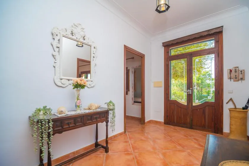 A bright entryway with wooden glass doors and a narrow console table.