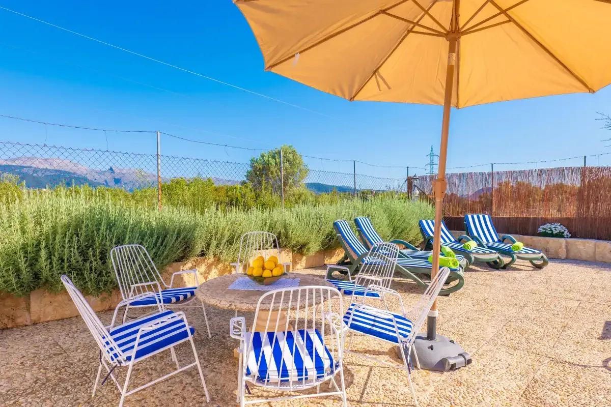 An outdoor seating area with striped chairs, a table, and a large umbrella.
