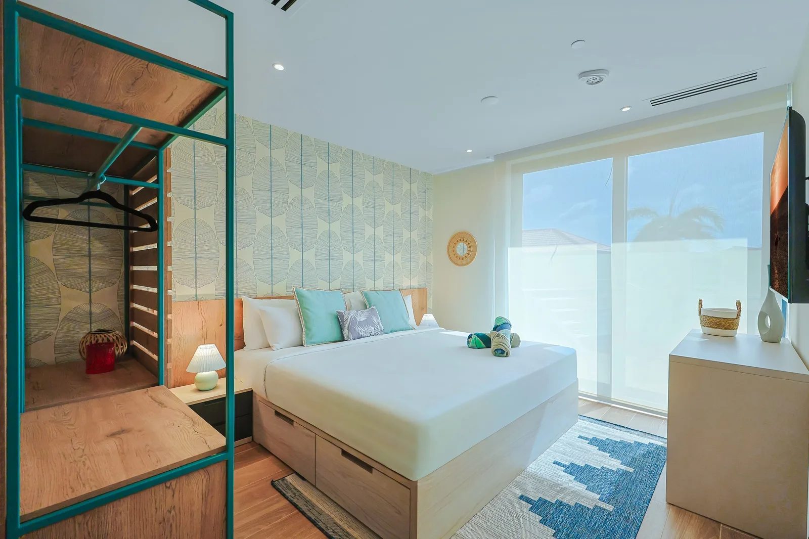 Your bright bedroom invites rest with coastal accents and natural light—crisp linens, soothing teal tones, make this space feel like home.