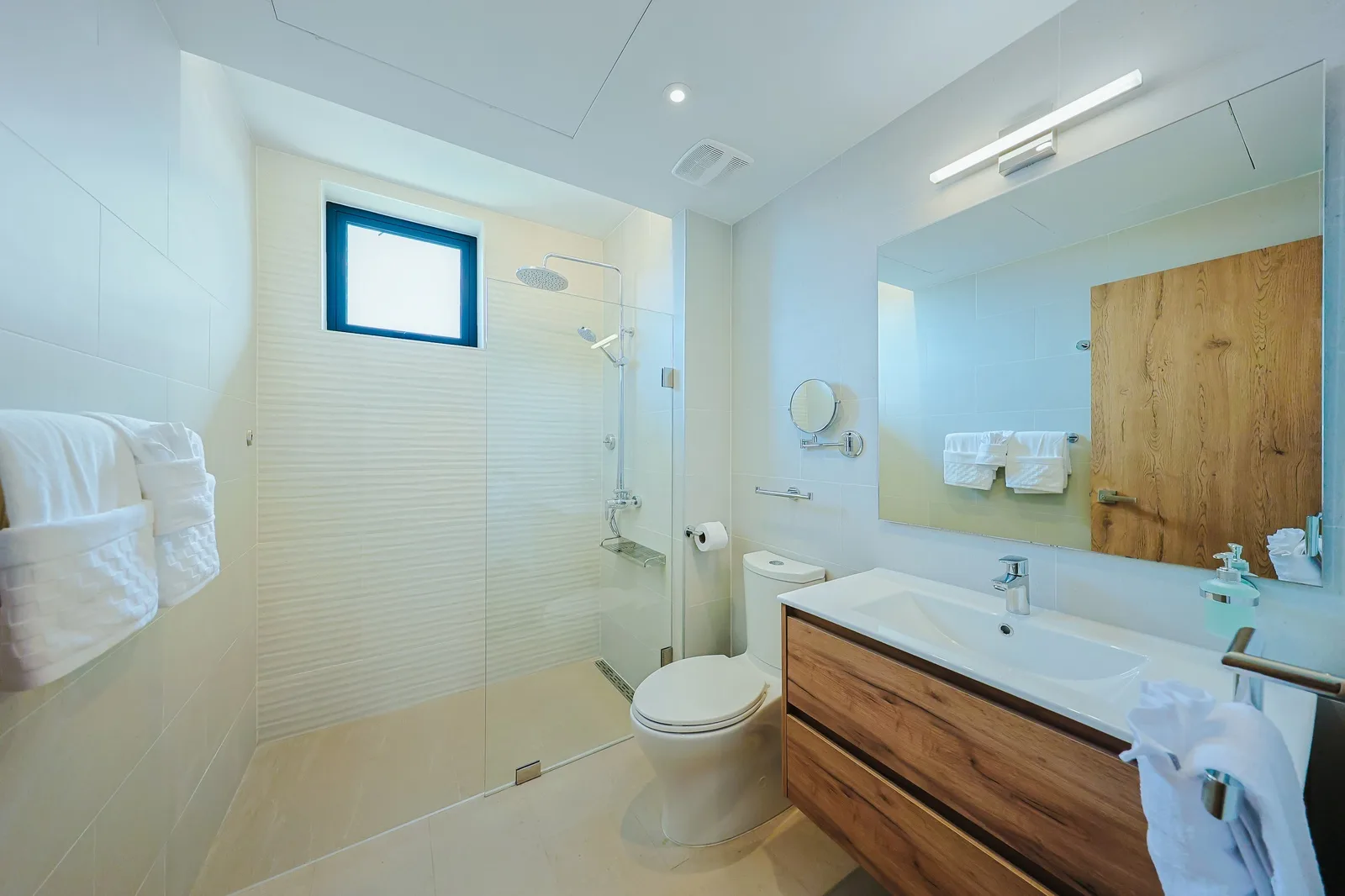 Step into your modern ensuite bathroom, where the rainfall shower and warm wood vanity create a spa-like retreat. Fresh towels and thoughtful lighting make every morning feel indulgent.