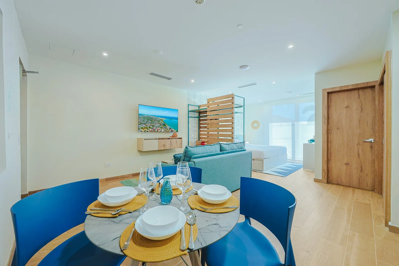 Your bright, open living space features a stylish dining table ready for meals, a cozy seating area with plush furnishings, and modern coastal touches that invite you to unwind in comfort.