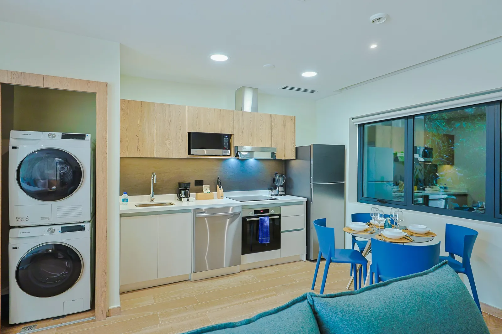 Modern open-plan space with sleek kitchen, vibrant dining area, and in-unit laundry—designed for your comfort and convenience during a relaxing stay.