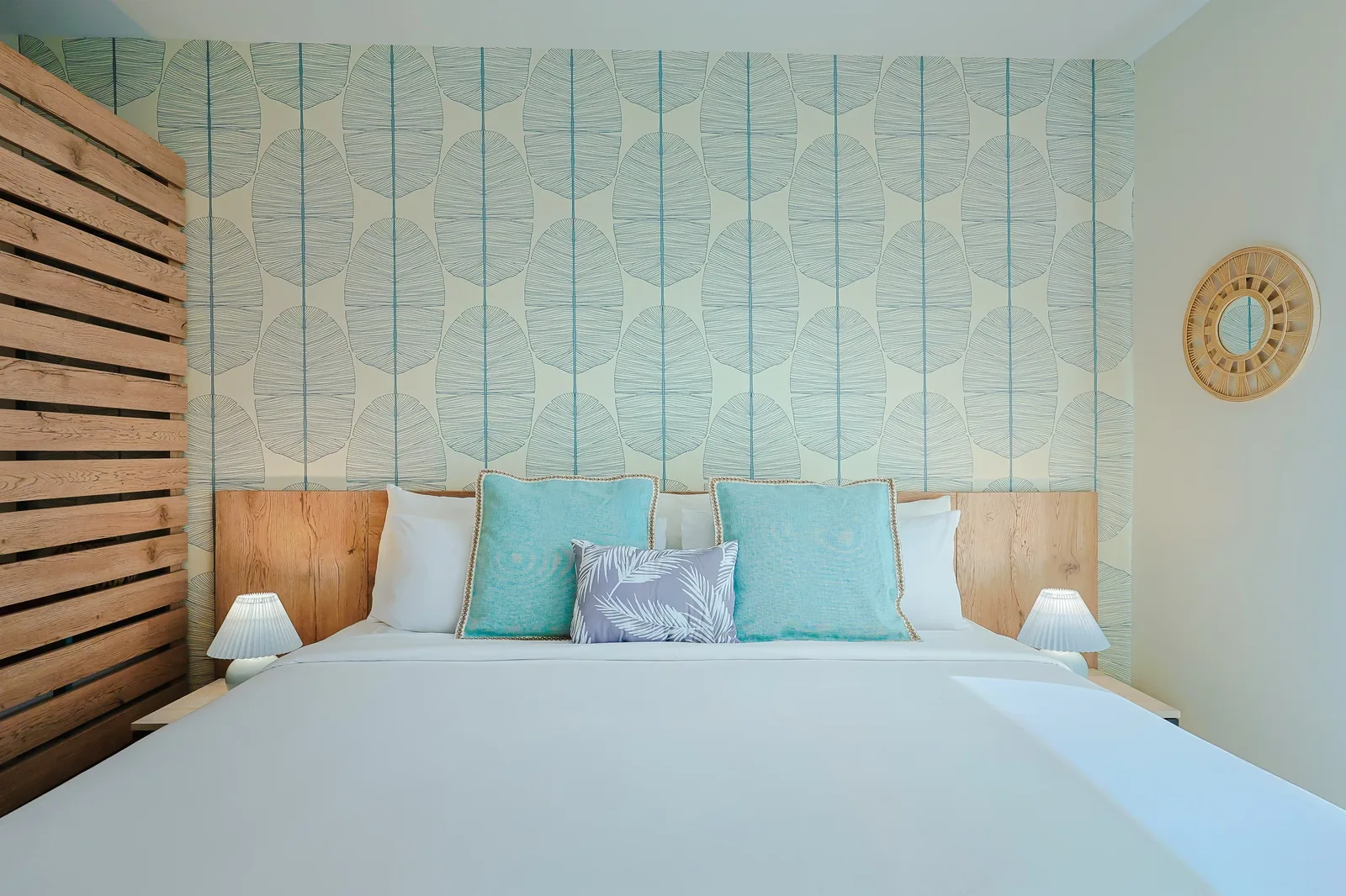 Slip into crisp linens and plush pillows in your coastal-inspired bedroom, where calming turquoise accents and natural wood textures create your perfect retreat.