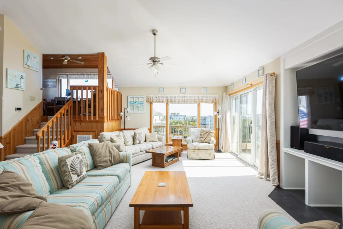 A bright living room with seating, a coffee table, and large glass doors.