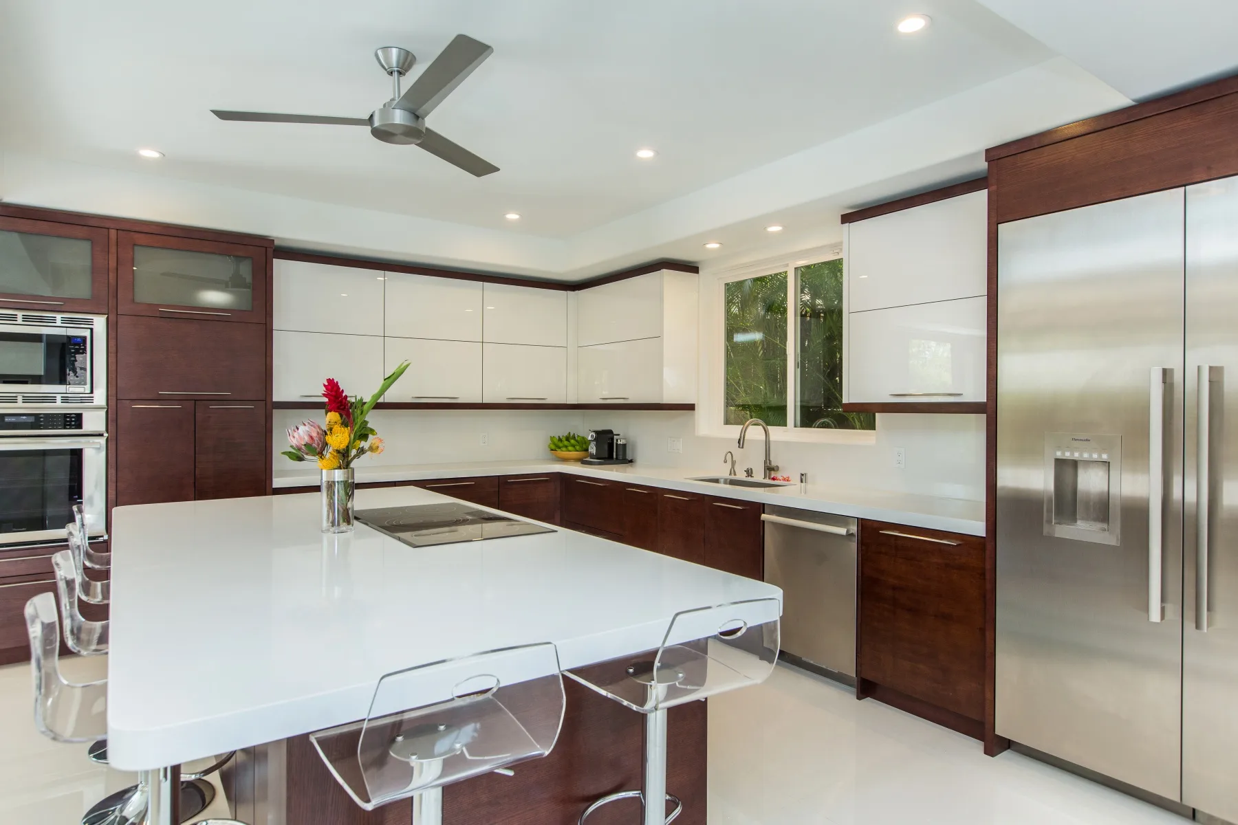 Una cocina moderna con una isla grande, gabinetes de madera oscura y electrodomésticos de acero inoxidable.