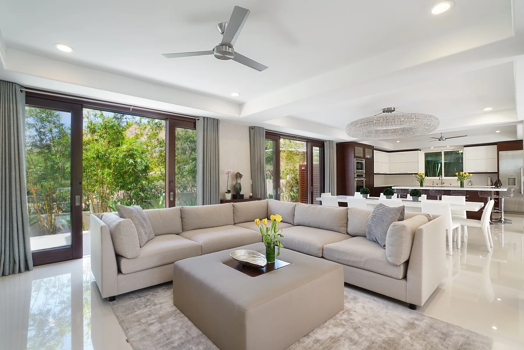 A bright living room with a sectional seating area and an open kitchen.