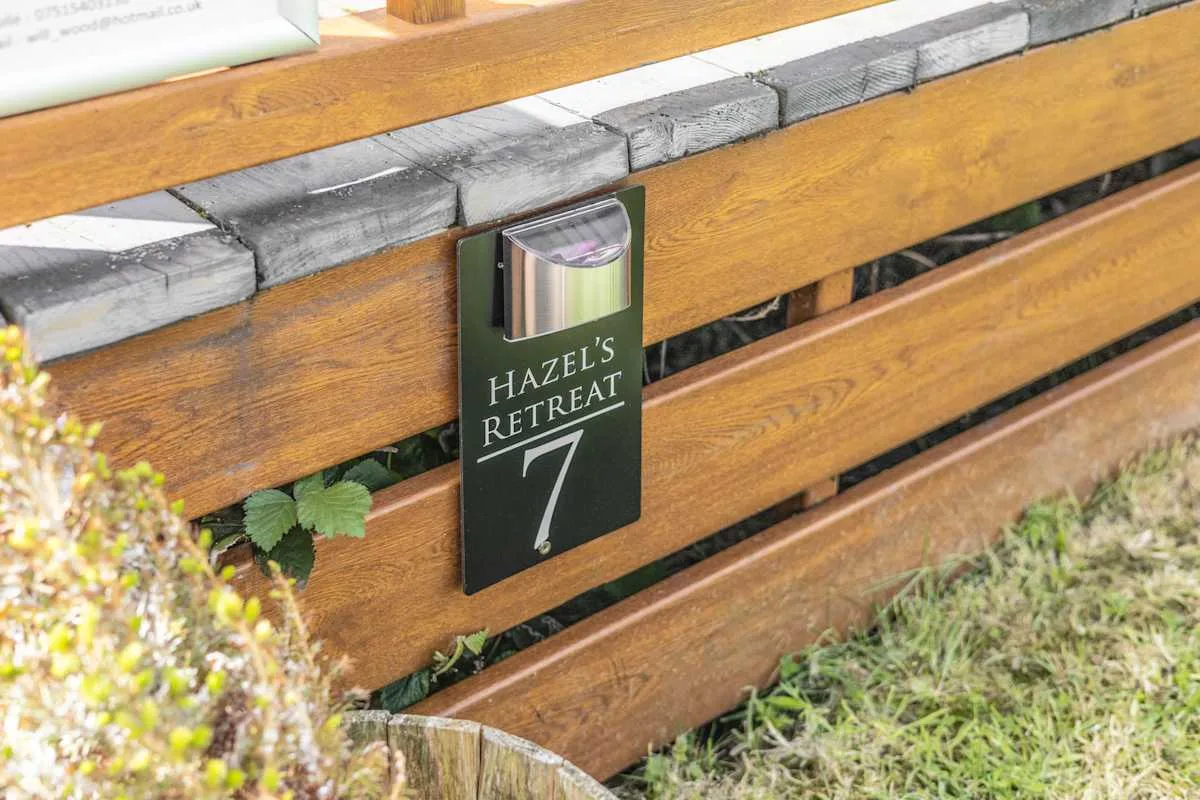 Una cerca de madera con un letrero que dice Hazel’s Retreat.