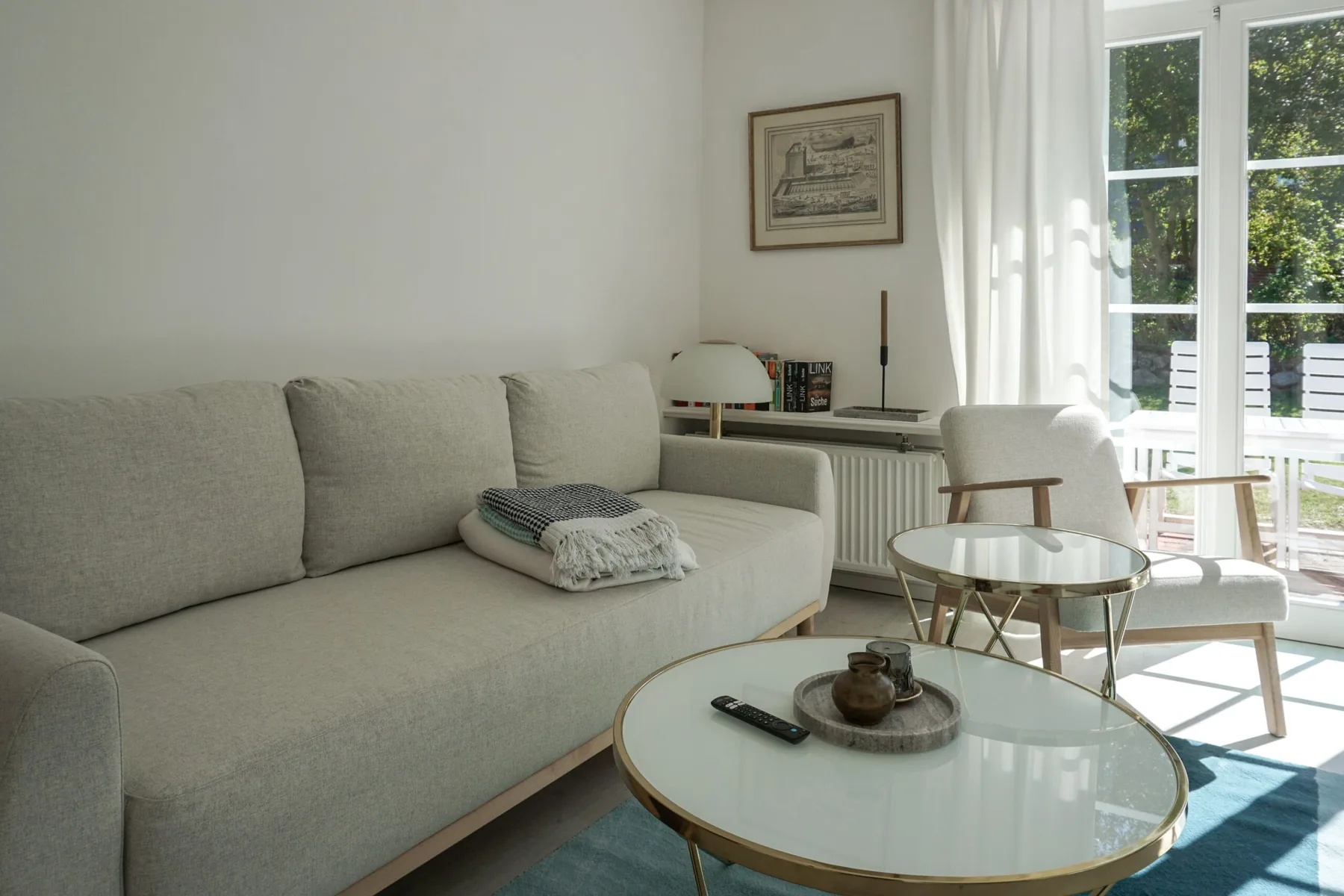 Una sala luminosa con asientos claros y una mesa de centro de vidrio.