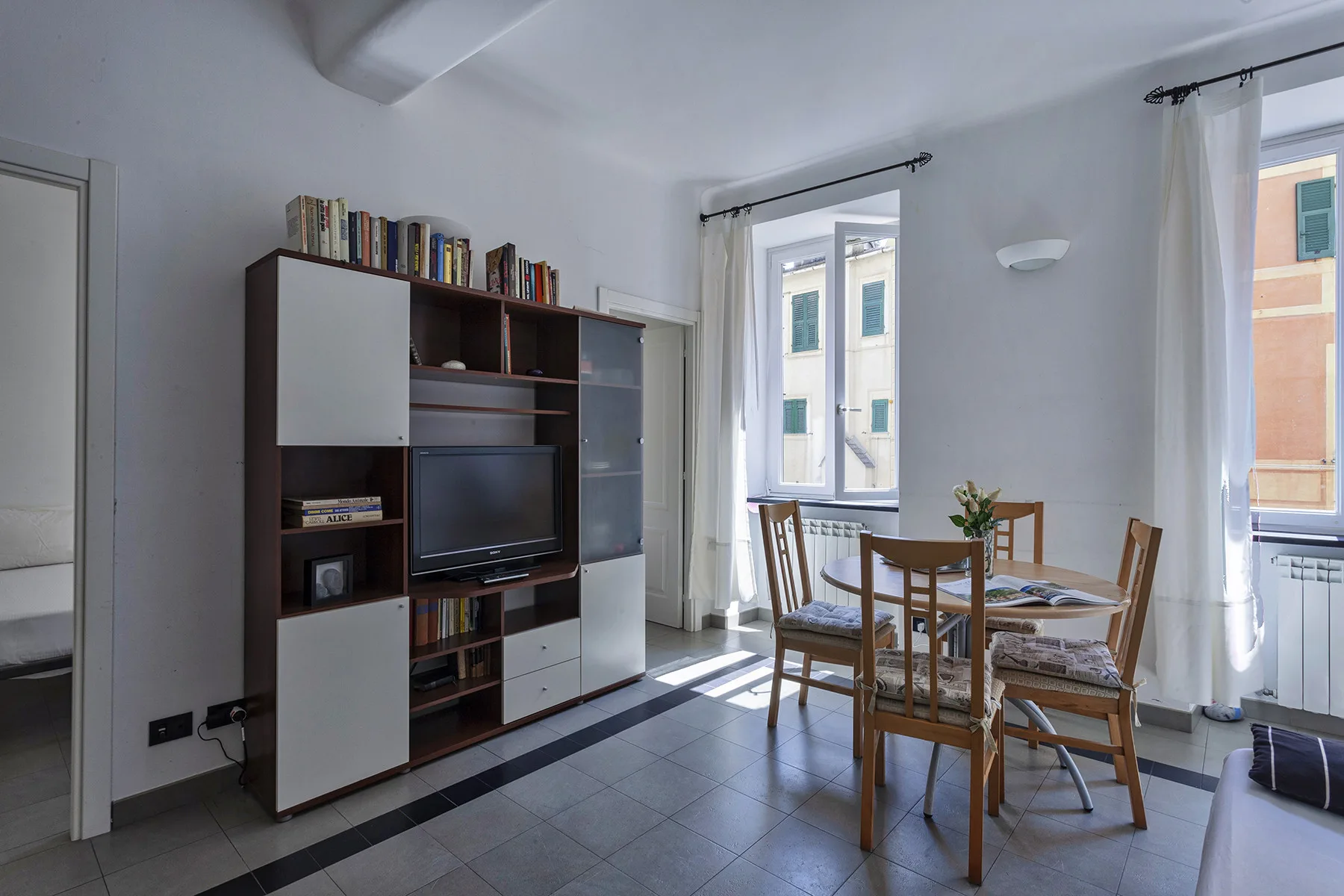 A living and dining area with a television cabinet and a wooden dining table.