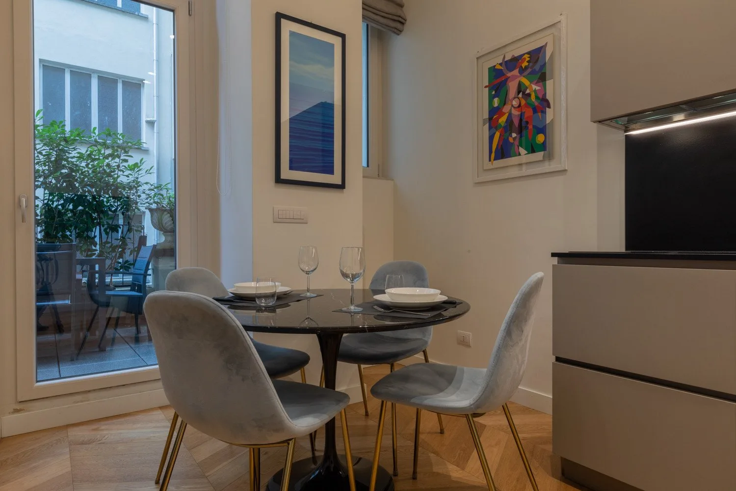 Un comedor con una mesa redonda y cuadros en las paredes.