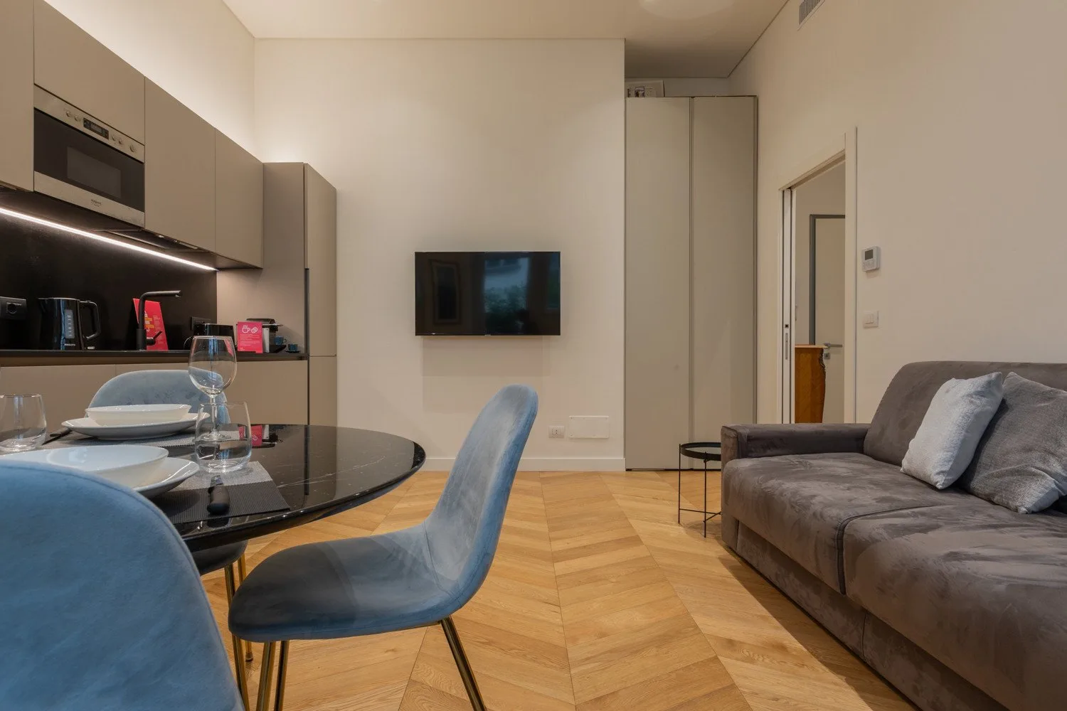 Una sala de estar con mesa de comedor, televisor y asientos.