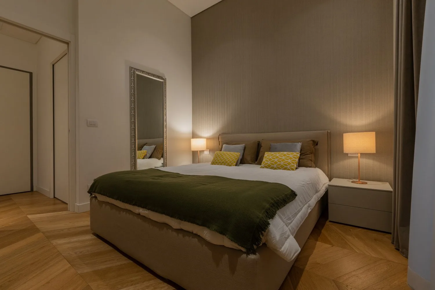Un dormitorio con una cama arreglada y lámparas de mesita a juego.