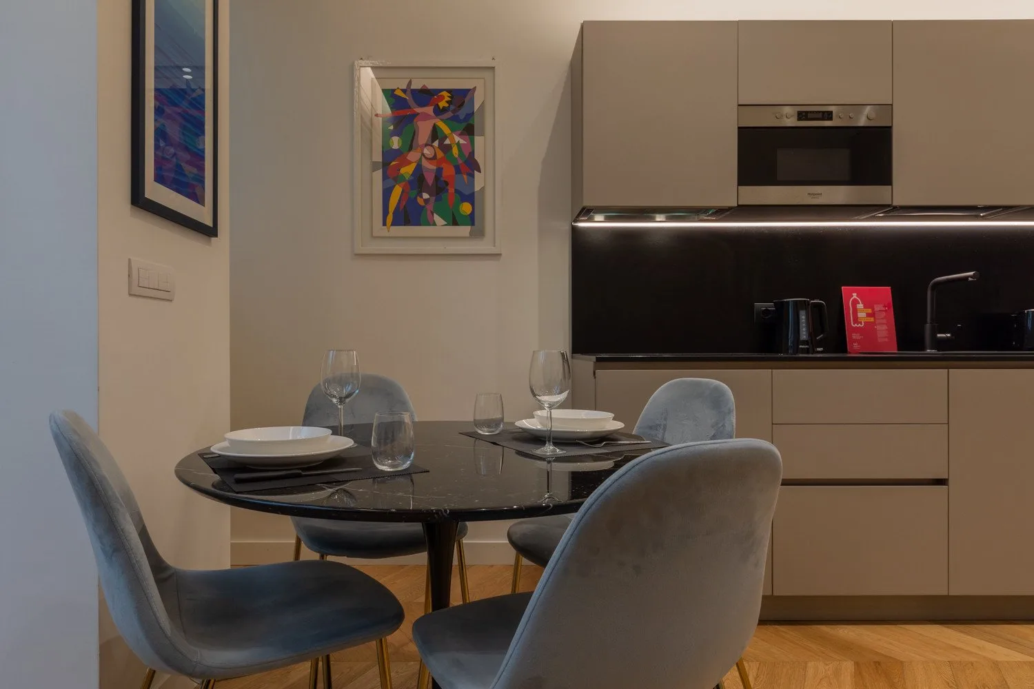 Comedor con una mesa redonda y asientos junto a una cocina moderna.