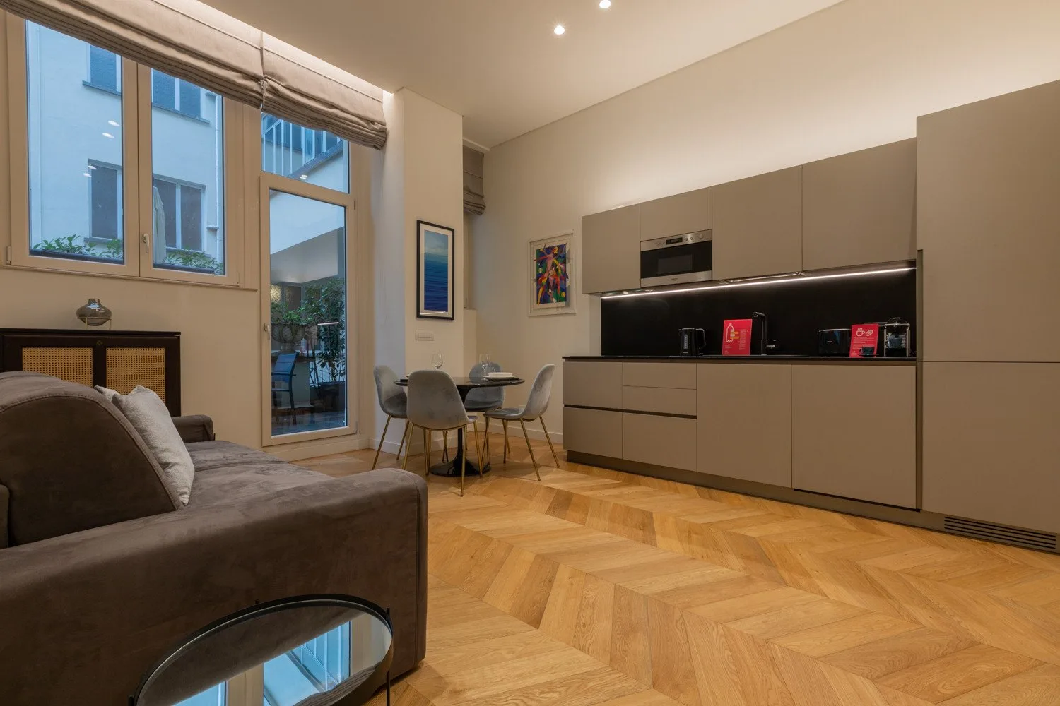 Sala de estar y comedor con sofá, mesa y cocina equipada.