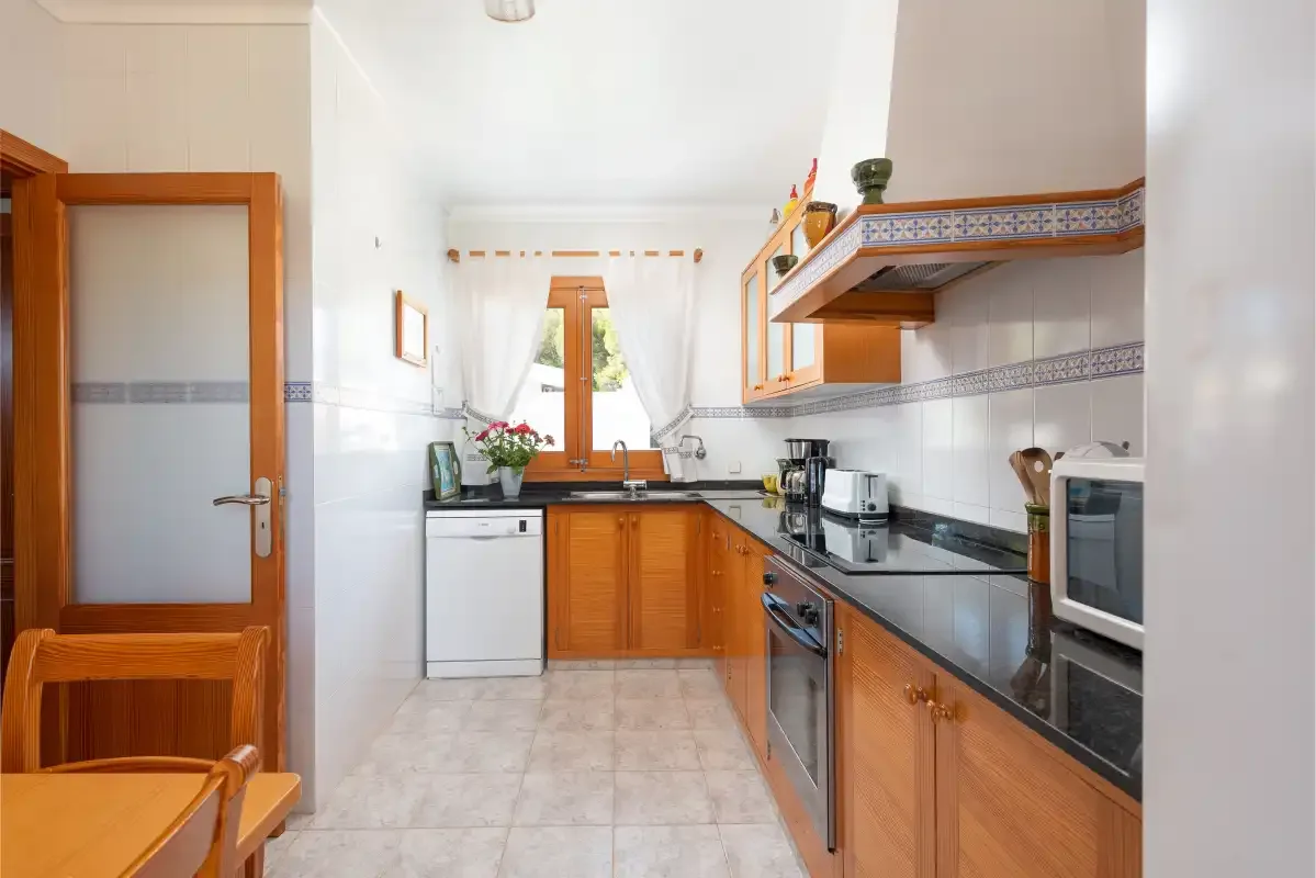 Una cocina luminosa con armarios de madera y una ventana sobre el fregadero.