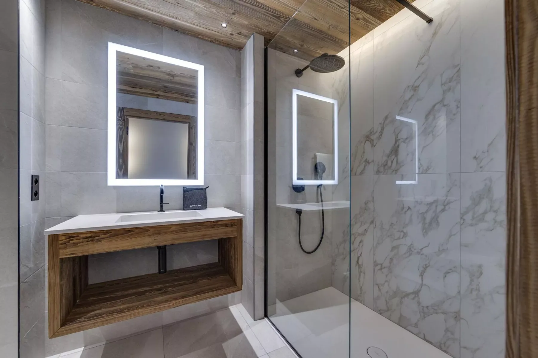 Un baño moderno con un tocador de madera y una ducha con mampara de vidrio.