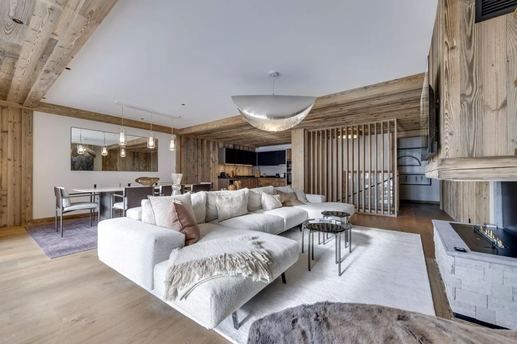 An open-plan living and dining area features a large seating arrangement and a dining table.