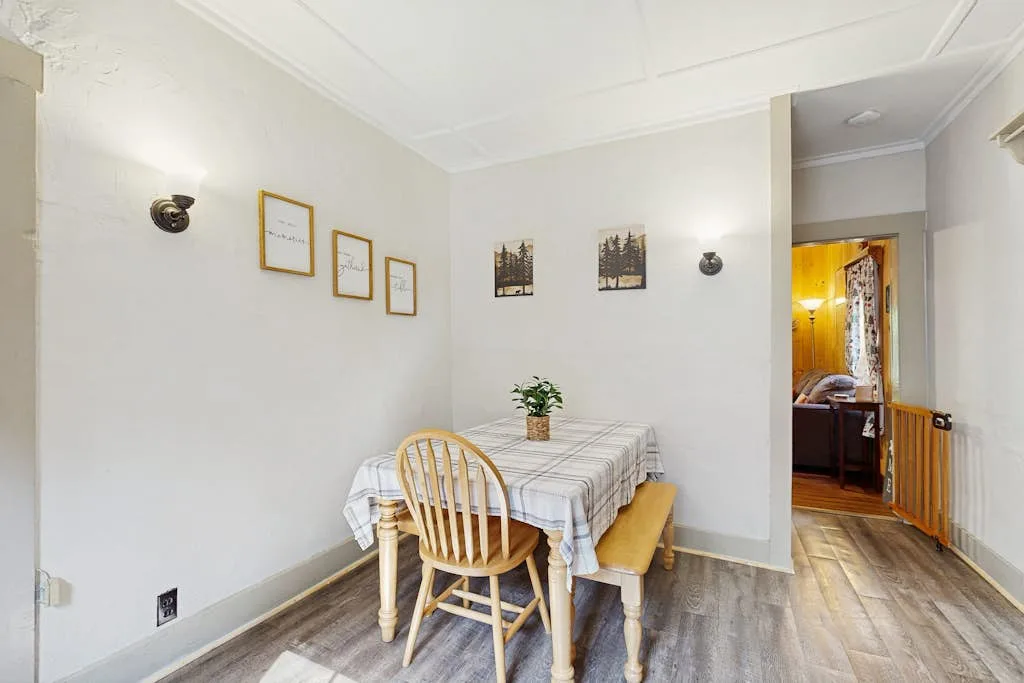 Comedor con una mesa, sillas y cuadros en las paredes.
