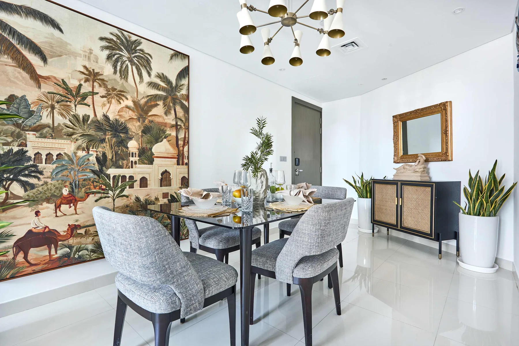Un comedor luminoso tiene una mesa y asientos tapizados junto a un gran mural.