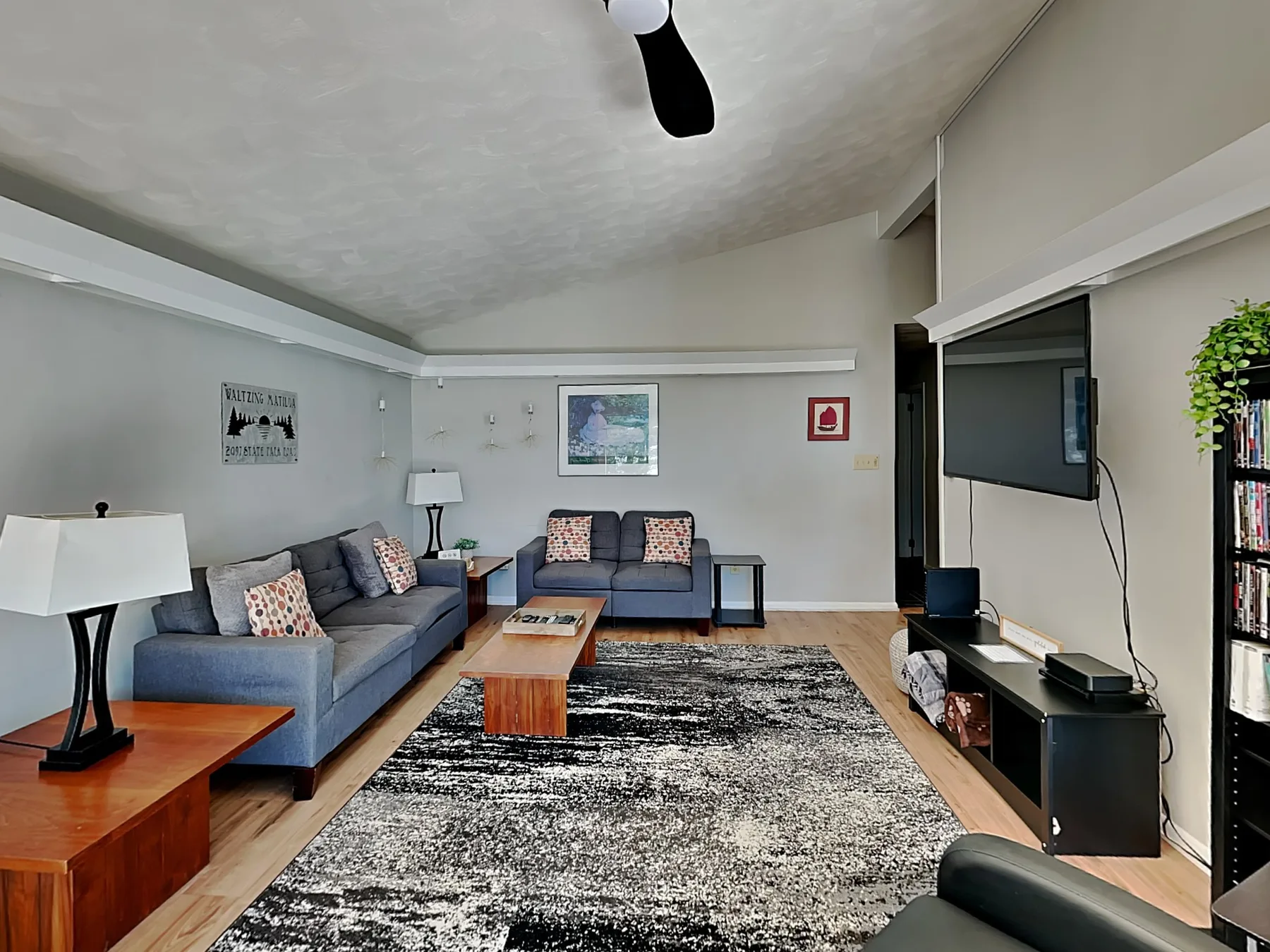 A living room with gray seating arranged around a coffee table and rug.