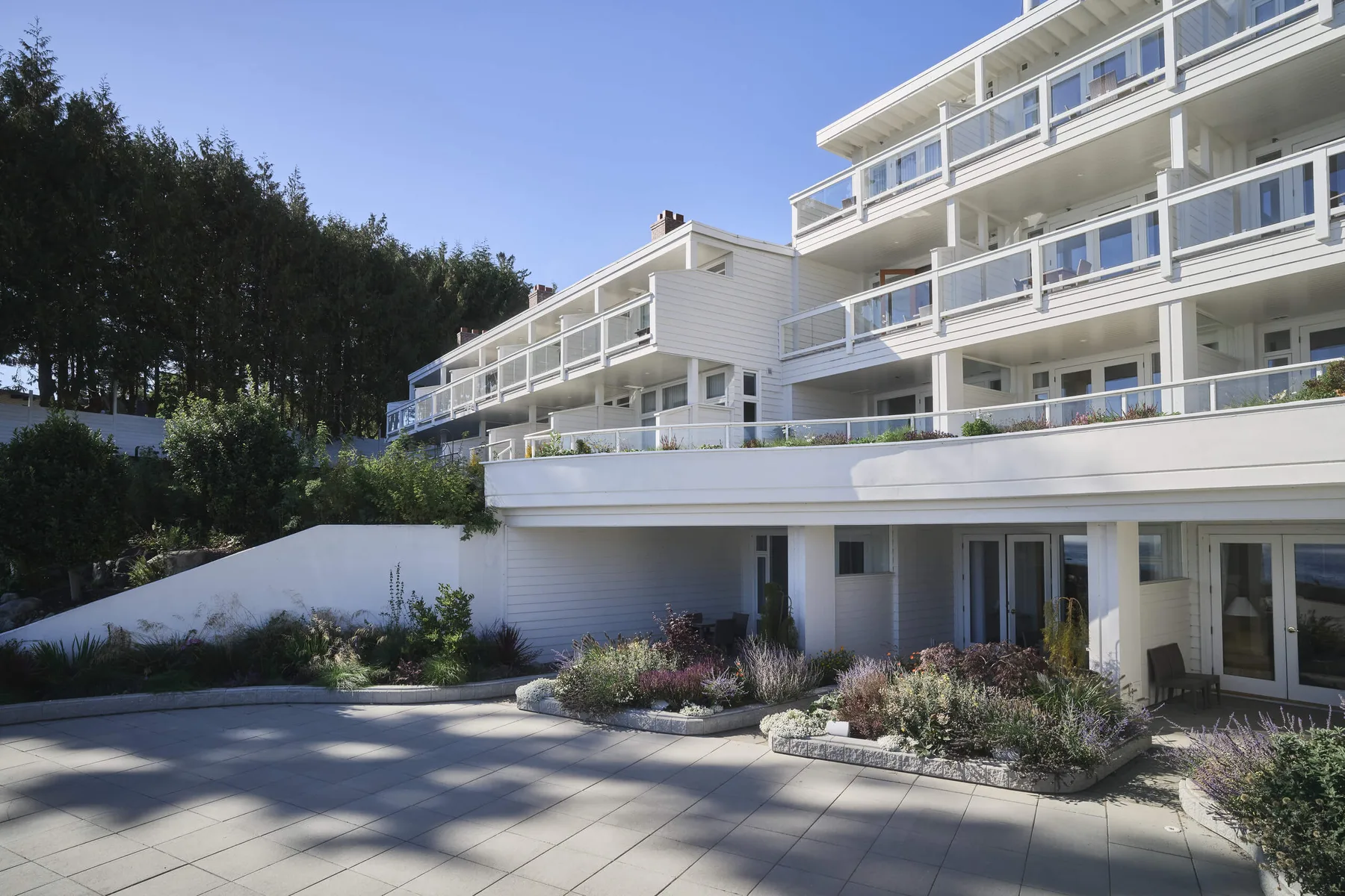 Sooke Harbour House exterior with balconies and garden beds.