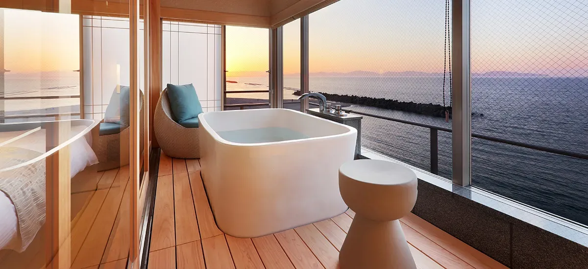 Habitación de estilo japonés moderno con dos camas individuales y baño con vistas