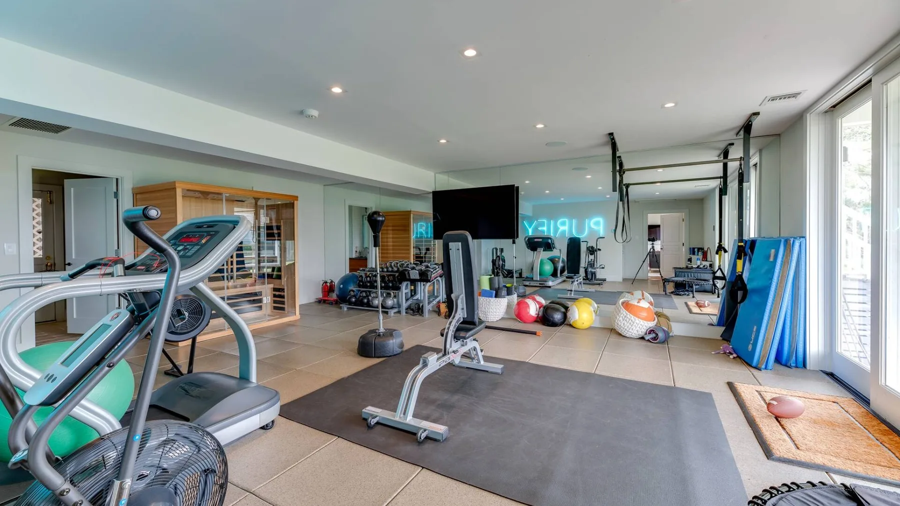 Un gimnasio con máquinas de ejercicio y pesas en el suelo.