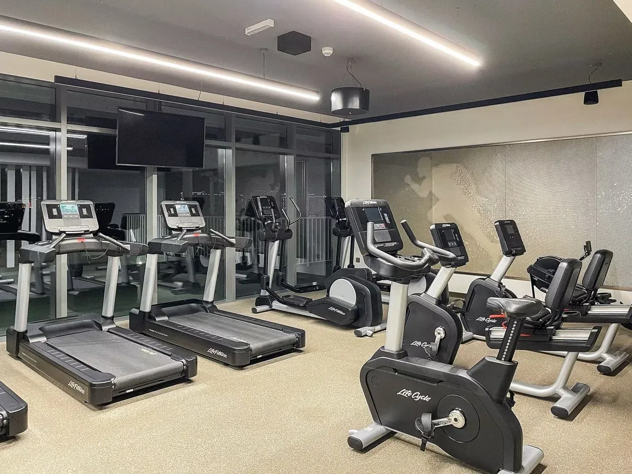 Un gimnasio con cintas de correr y bicicletas estáticas.