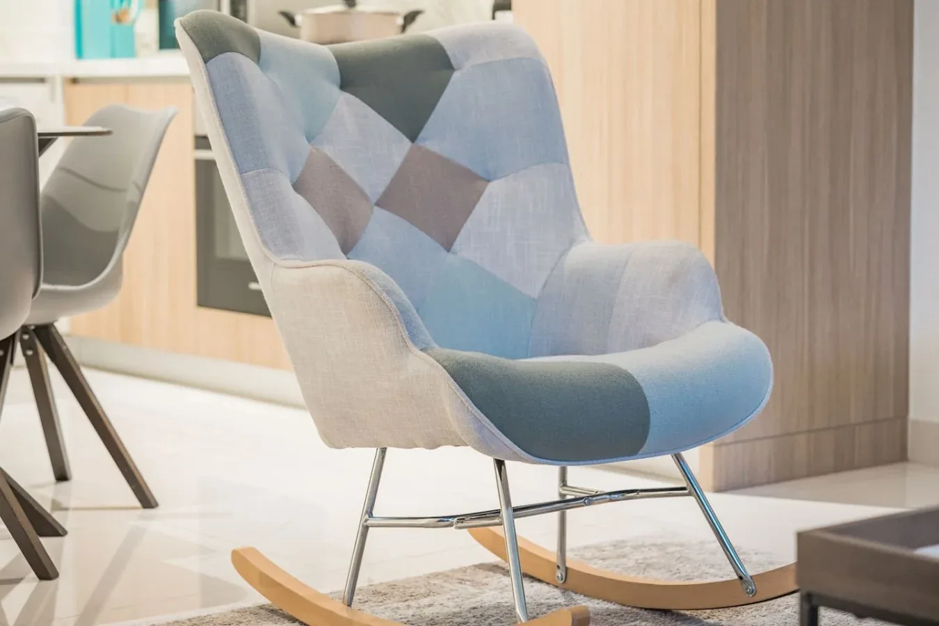 Un sillón colorido está junto a un comedor en una habitación luminosa.