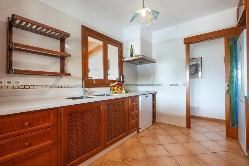 A kitchen with wooden cabinets, a countertop, and a sink.