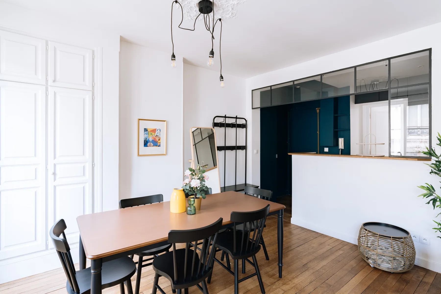 Un comedor luminoso con una mesa de madera y asientos negros.