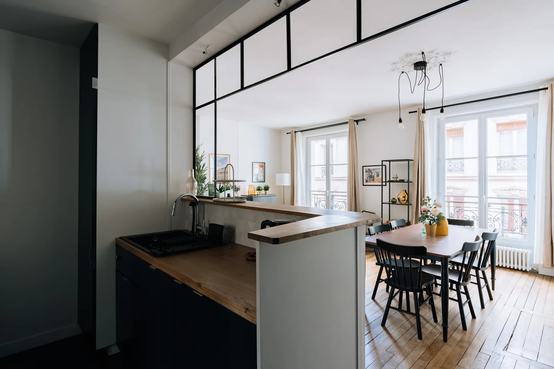 Una cocina abierta y zona de comedor con una barra central y una mesa.